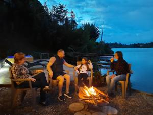 a group of people sitting around a fire at Lodge in Guatapé, Cottage on the Lake with Jacuzzi in Guatapé