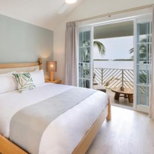 um quarto com uma grande cama branca e uma varanda em Islander Bayside Villas & Boatslips em Islamorada