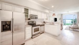una cocina con armarios blancos y electrodomésticos de acero inoxidable en Islander Bayside Villas & Boatslips en Islamorada