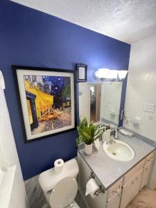 baño con aseo y lavamanos con una pintura en la pared en Cozy 3bd Family-friendly Home (Near Ft. Sill & VA), en Lawton
