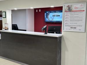 a reception counter with a phone on the wall at Red Roof Inn Flint in Flint