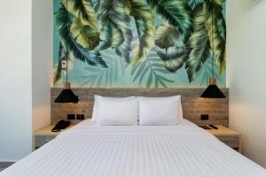 1 dormitorio con 1 cama con un mural de hojas en Sea Avenue Hotel, en San Andrés