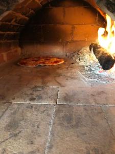 um forno de pizza com duas pizzas dentro em Villa Marija em Ljubuski