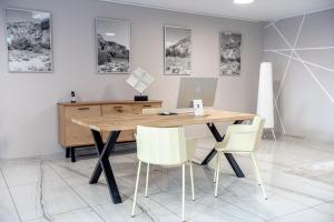 an office with a wooden desk and white chairs at Miralago Locarno Easy Rooms in Locarno