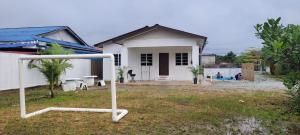 a white house with a soccer ball in front of it at Cantik-La Homestay Kolam 6 Bilik Kuala Terengganu in Bukit Payong