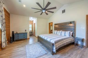 um quarto com uma cama grande e uma ventoinha de tecto em Luxe Hot Springs Cabin w/Pond and Game Room! em Pearcy