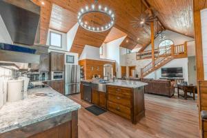 uma grande cozinha com tectos em madeira e uma escadaria em Luxe Hot Springs Cabin w/Pond and Game Room! em Pearcy
