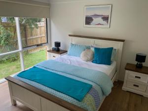 a bedroom with a bed with blue pillows at Beauna Vista Rye Retreat Home in Rye