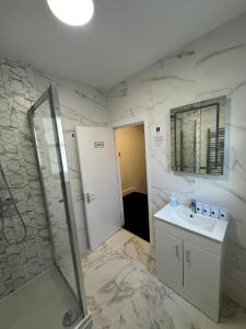 a bathroom with a shower and a sink and a mirror at Cambridge Central Rooms - Tas Accommodations in Cambridge
