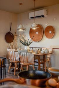 ein Esszimmer mit einem Tisch und Stühlen sowie Töpfen und Pfannen in der Unterkunft Casa Tosca in Fátima