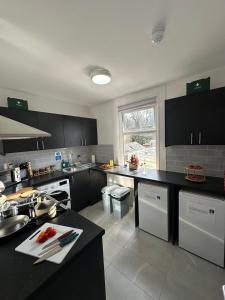 a kitchen with black counters and white appliances at Cambridge Central Rooms - Tas Accommodations in Cambridge +50 photos
