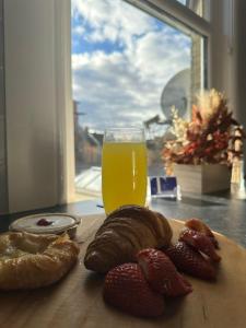 a cutting board with bread and a glass of orange juice at Cambridge Central Rooms - Tas Accommodations in Cambridge