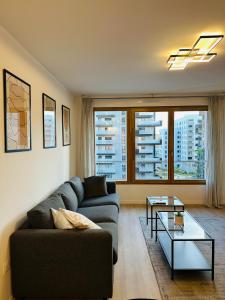 a living room with a couch and a table at SKY - ASNIERES in Asnières-sur-Seine