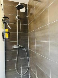 a shower with a metal wall in a bathroom at SKY - ASNIERES in Asnières-sur-Seine