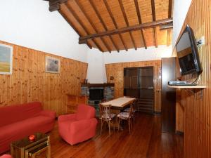 sala de estar con sofá rojo y mesa en Annita Holiday Home, en Dervio