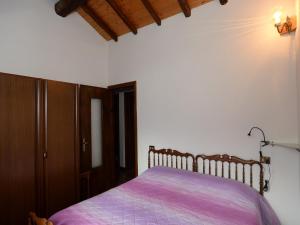 sypialnia z łóżkiem z fioletowym kocem w obiekcie Annita Holiday Home w mieście Dervio