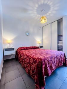 1 dormitorio con 1 cama grande con manta roja en “Tu lugar en Cordoba 02” Depto SADIMA Guemes en Córdoba
