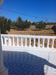 a white railing on a porch with a view at l'olivier in Aghīr