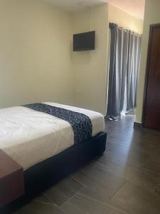 a bedroom with a bed and a television on the wall at REGMAR Progreso Yucatán in Progreso