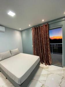 a bedroom with a bed and a large window at Sobrado aconchegante e espaçoso, ótima opção! in Foz do Iguaçu