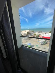 a room with a view of the beach from a window at REGMAR Progreso Yucatán in Progreso