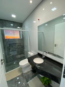 a bathroom with a toilet and a sink and a mirror at Sobrado aconchegante e espaçoso, ótima opção! in Foz do Iguaçu