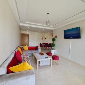 un soggiorno con divano e tavolo di COSTA BEACH Lux Family Apartment with Pools a Bouznika