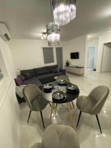 a living room with a couch and a table and chairs at Apartman Marina stan na dan in Prijedor