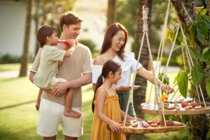 a family standing in front of a table with food at Danang Marriott Resort & Spa, Non Nuoc Beach Villas in Da Nang