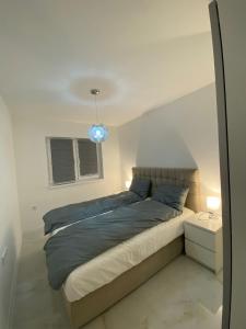 a bedroom with a large bed with a blue light at Apartman Marina stan na dan in Prijedor