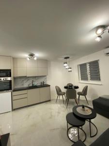 a kitchen and a living room with tables and chairs at Apartman Marina stan na dan in Prijedor
