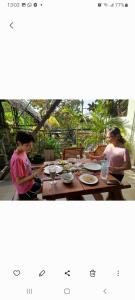 zwei Frauen, die an einem Tisch sitzen mit Teller Essen in der Unterkunft Sacred City Tourist Resort in Anuradhapura