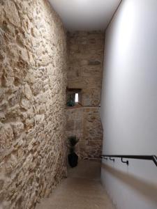 a hallway with a stone wall and a staircase at A Taberna de Gundián in Vedra