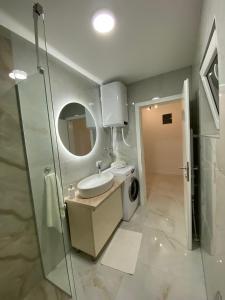 a bathroom with a sink and a washing machine at Apartman Marina stan na dan in Prijedor