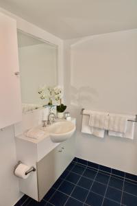 a white bathroom with a sink and a mirror at City Stadium 2 in Townsville