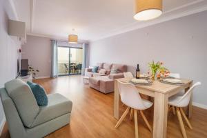 a living room with a table and a couch at Lovely&Cozy apartment in Lagoa