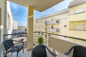 a balcony with chairs and a view of a street at Lovely&Cozy apartment in Lagoa