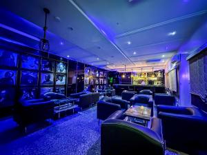 a room with blue lighting and couches and a bar at Parkview Astoria Hotel in Lagos