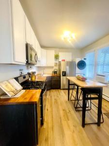 a kitchen with white cabinets and a wooden floor at Beautiful Chicago 2BD 1BA in Chicago