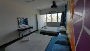 una habitación con dos camas y una ventana en Panamerican Hostel, en Santa Marta
