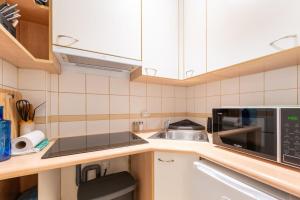 a kitchen with a sink and a microwave at Cosy & Well-Connected 1BD ApartmentSaint Lazare in Paris