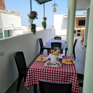 une table avec un chiffon de table rouge et blanc dans l'établissement Hotel Dreimar, à Carthagène des Indes