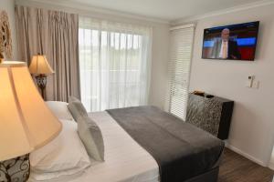 a bedroom with a bed and a window with a tv at City Stadium 2 in Townsville