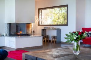 una sala de estar con chimenea y un jarrón de flores en Villa HAPPY DAYS, en Pietrosella