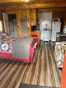 a bedroom with a bed and a kitchen in a cabin at South Fork Lodge & RV Park Colorado in South Fork