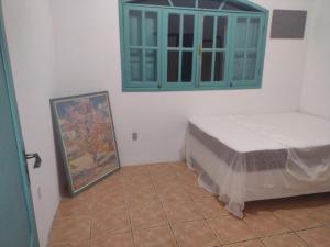 - une chambre avec un lit, une armoire et un tableau dans l'établissement Cada De Hospedagem Vida No Paraíso, à Angra dos Reis