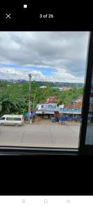 een raam met uitzicht op een straat met een wit busje bij Yang guest house/private room in Dauis