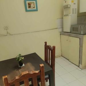 cocina con mesa, sillas y nevera en Agradable minidepartamento central en Ambato, para una a seis personas, en Ambato