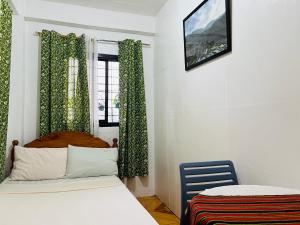 1 Schlafzimmer mit 2 Betten und einem Fenster in der Unterkunft Maria’s Place Homestay in Baguio City