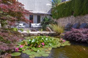 坎佩爾的住宿－Best Western Plus Hotel Kregenn，一座房子前面的池塘,池塘里满是鲜花和百合
